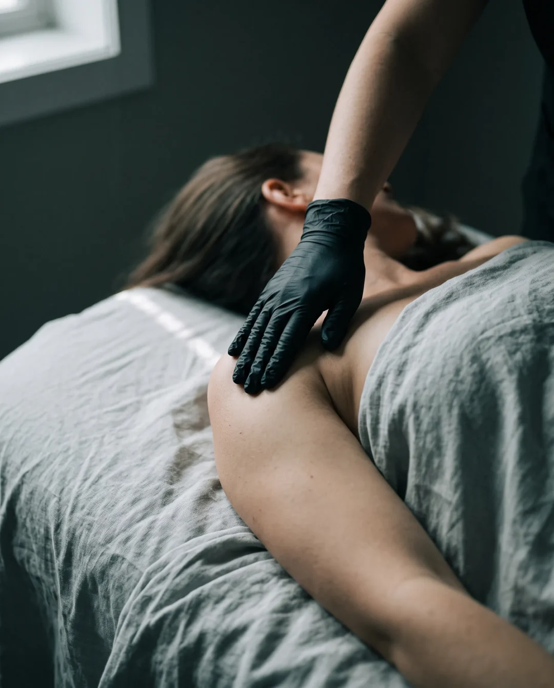 Certified therapist performing gentle manual lymphatic drainage on a patient's shoulder using the Vogel Method